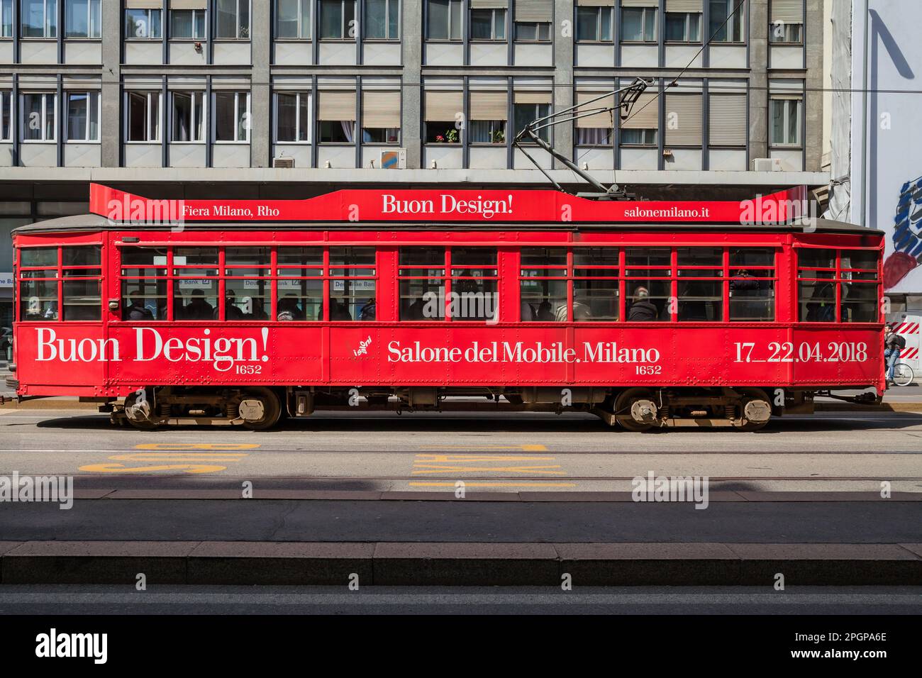 MAILAND, ITALIEN - APRIL 2018: Eine rote Straßenbahn, Symbol der Stadt, die durch die Straßen fährt und die Design Week anpreist, schrieb Salone del Mobile. Stockfoto