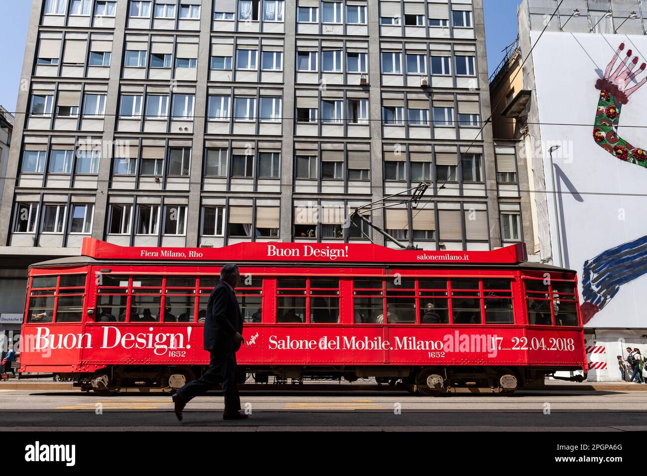 MAILAND, ITALIEN - APRIL 2018: Eine rote Straßenbahn, Symbol der Stadt, die durch die Straßen fährt und die Design Week anpreist, schrieb Salone del Mobile. Stockfoto