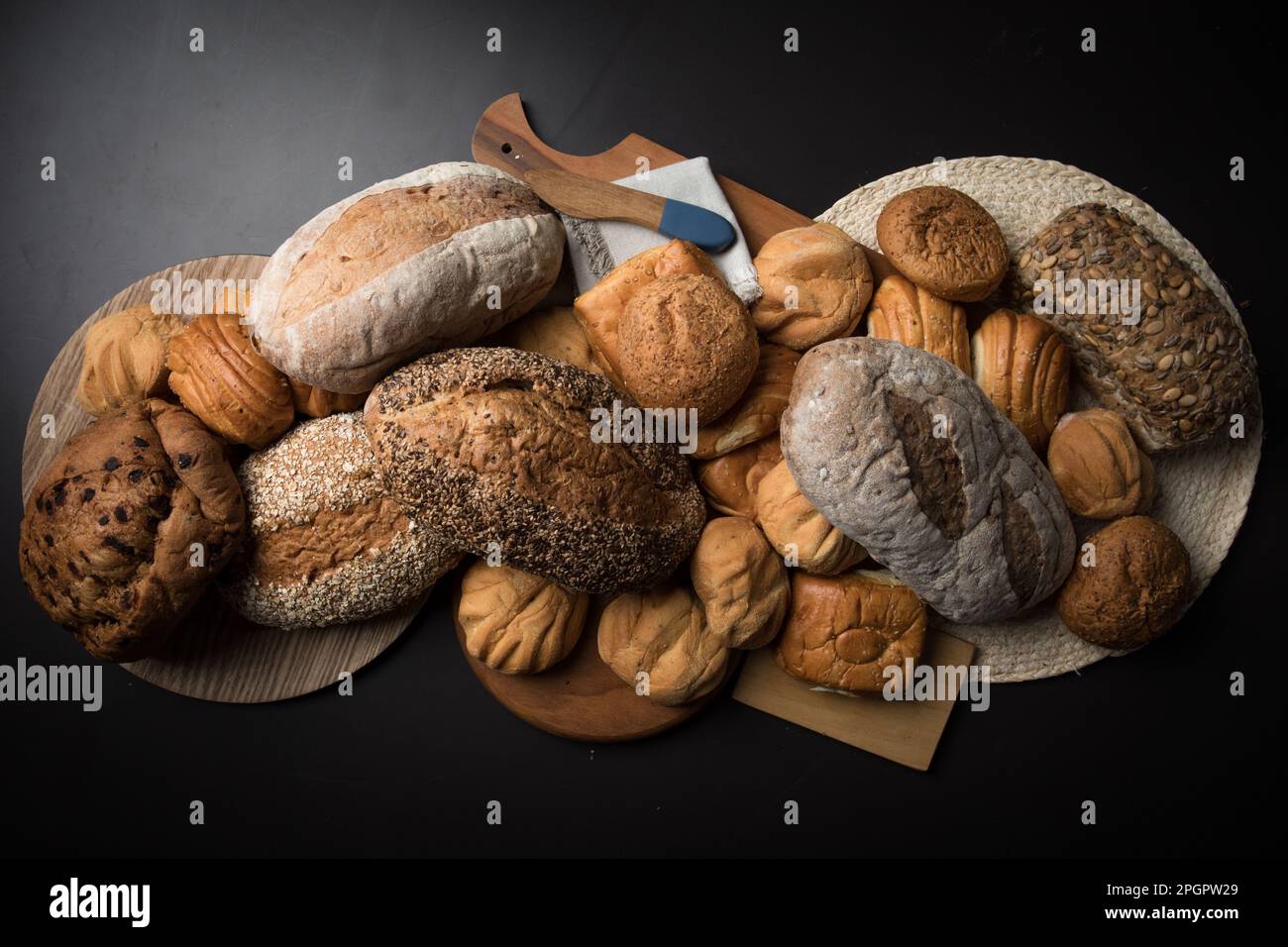 Verschiedene Brotsorten auf einem schwarzen Tisch Stockfoto