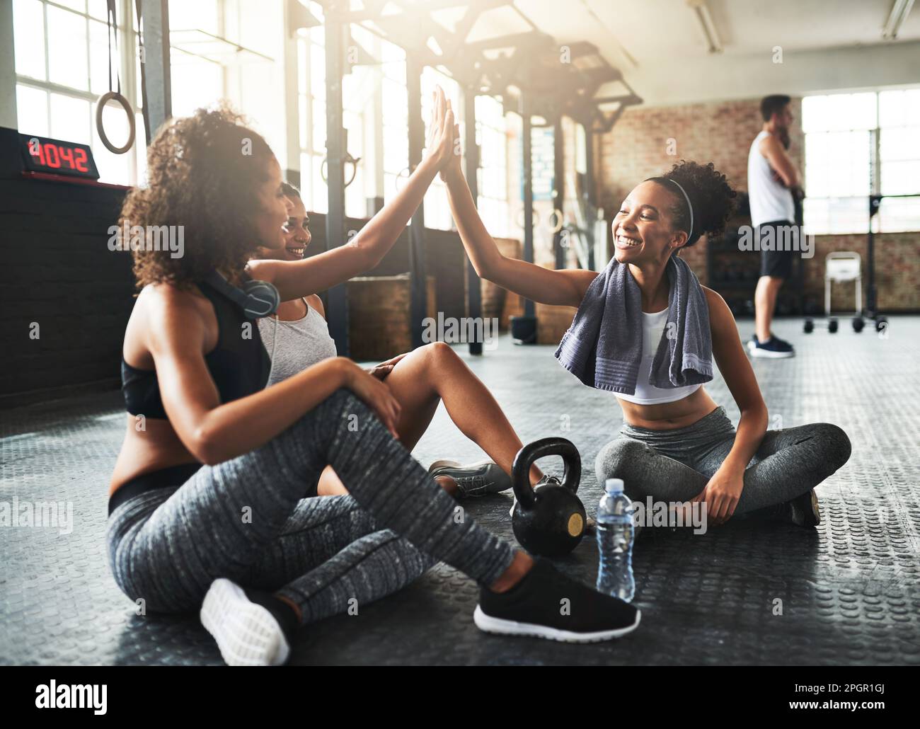 Stärke in Zahlen. Junge Frauen geben sich gegenseitig einen High Five, während sie eine Pause im Fitnessstudio machen. Stockfoto