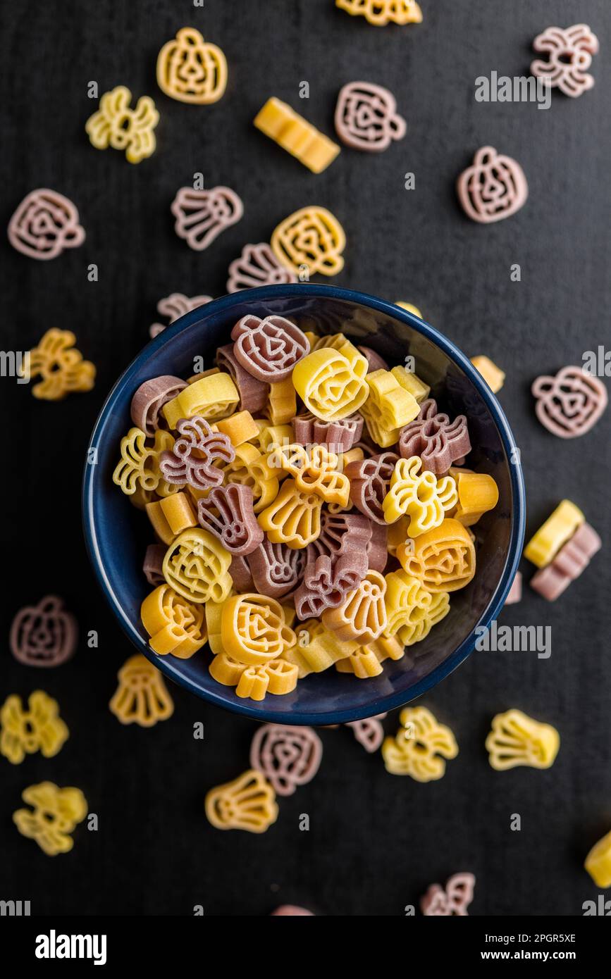 Pasta in verschiedenen unheimlichen Formen. Ungekochte halloween-Pasta in einer Schüssel. Draufsicht. Stockfoto
