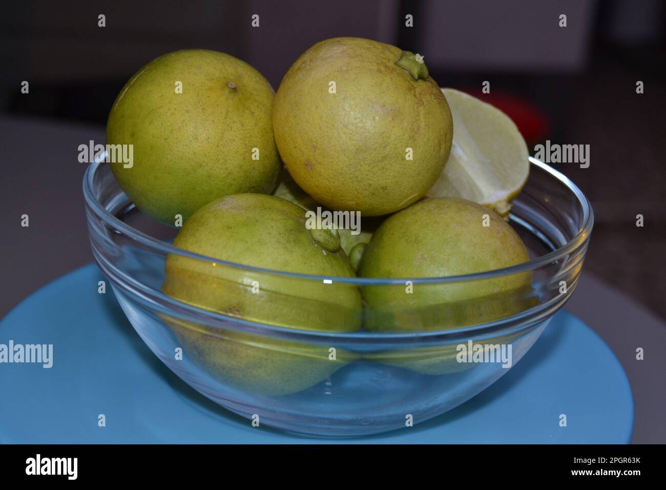 Reife Zitronen Früchte in einer Glasschüssel werden sofort in ein Getränk gepresst Stockfoto