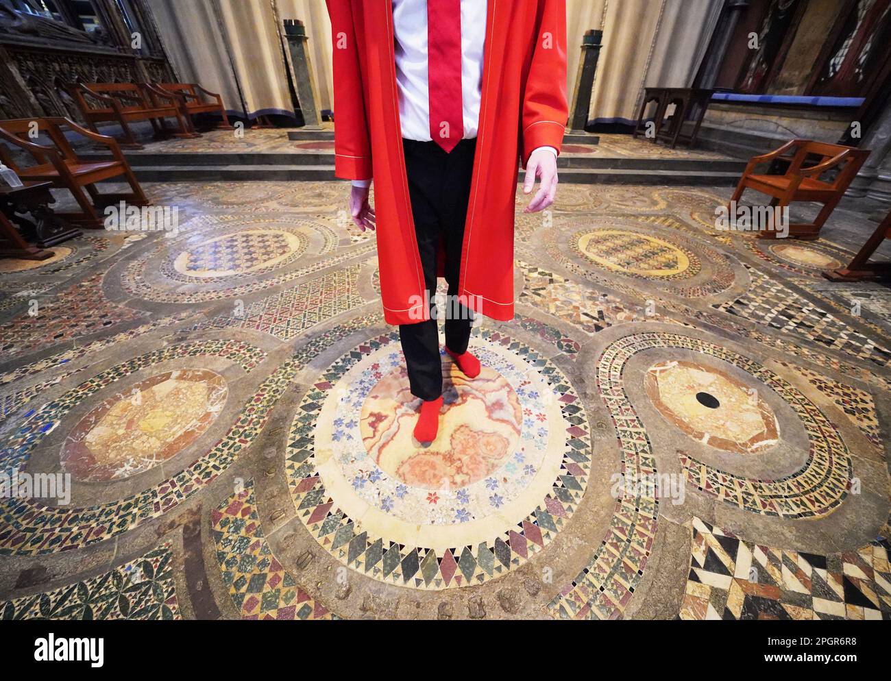 Abbey Marshal Howard Berry geht durch das Zentrum des Cosmati-Gehwegs, das sich vor dem Altar befindet, während eines Fotoanrufs in Westminster Abbey, im Zentrum von London, um besondere Veranstaltungen zur Krönung von König Karl III. Anzukündigen Foto: Donnerstag, 23. März 2023. Stockfoto