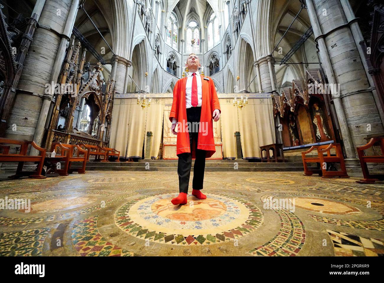 Abbey Marshal Howard Berry geht durch das Zentrum des Cosmati-Gehwegs, das sich vor dem Altar befindet, während eines Fotoanrufs in Westminster Abbey, im Zentrum von London, um besondere Veranstaltungen zur Krönung von König Karl III. Anzukündigen Foto: Donnerstag, 23. März 2023. Stockfoto