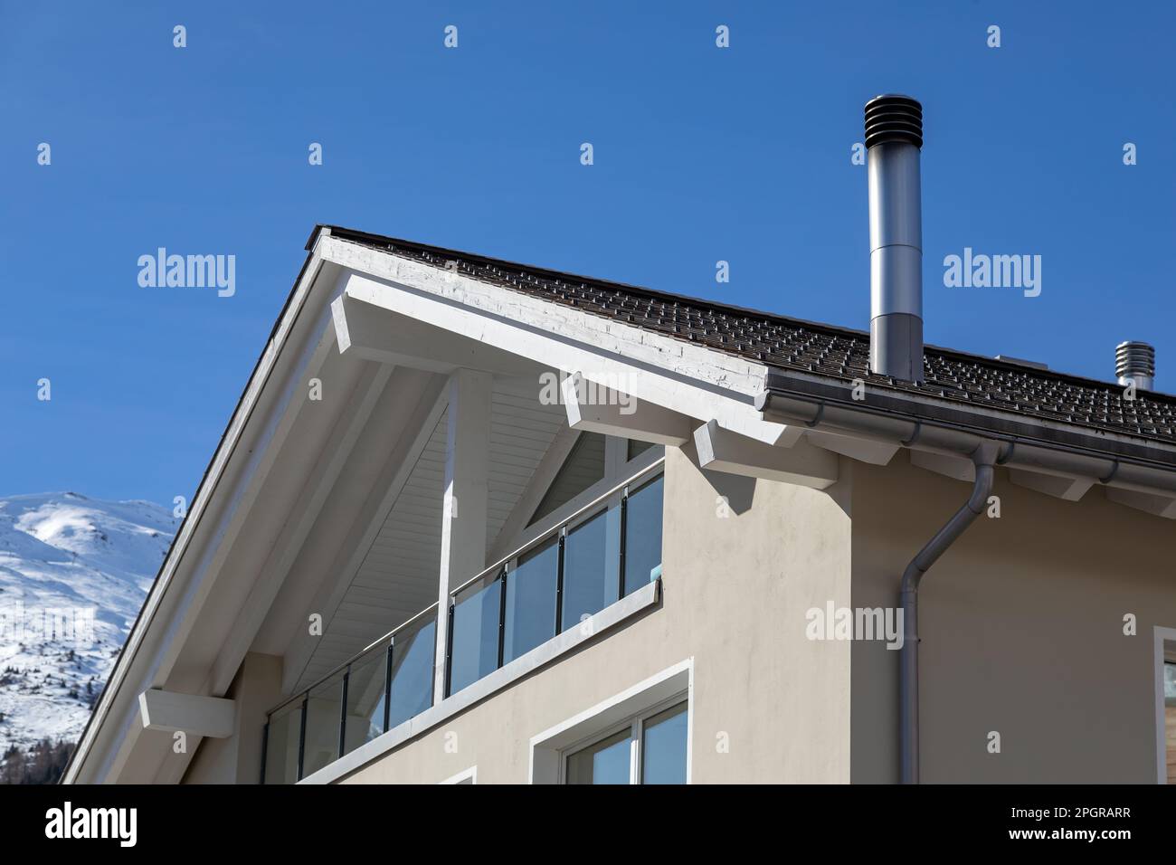 Rußiger Edelstahlschornstein auf dem Dach des Hauses in den alpen Stockfoto
