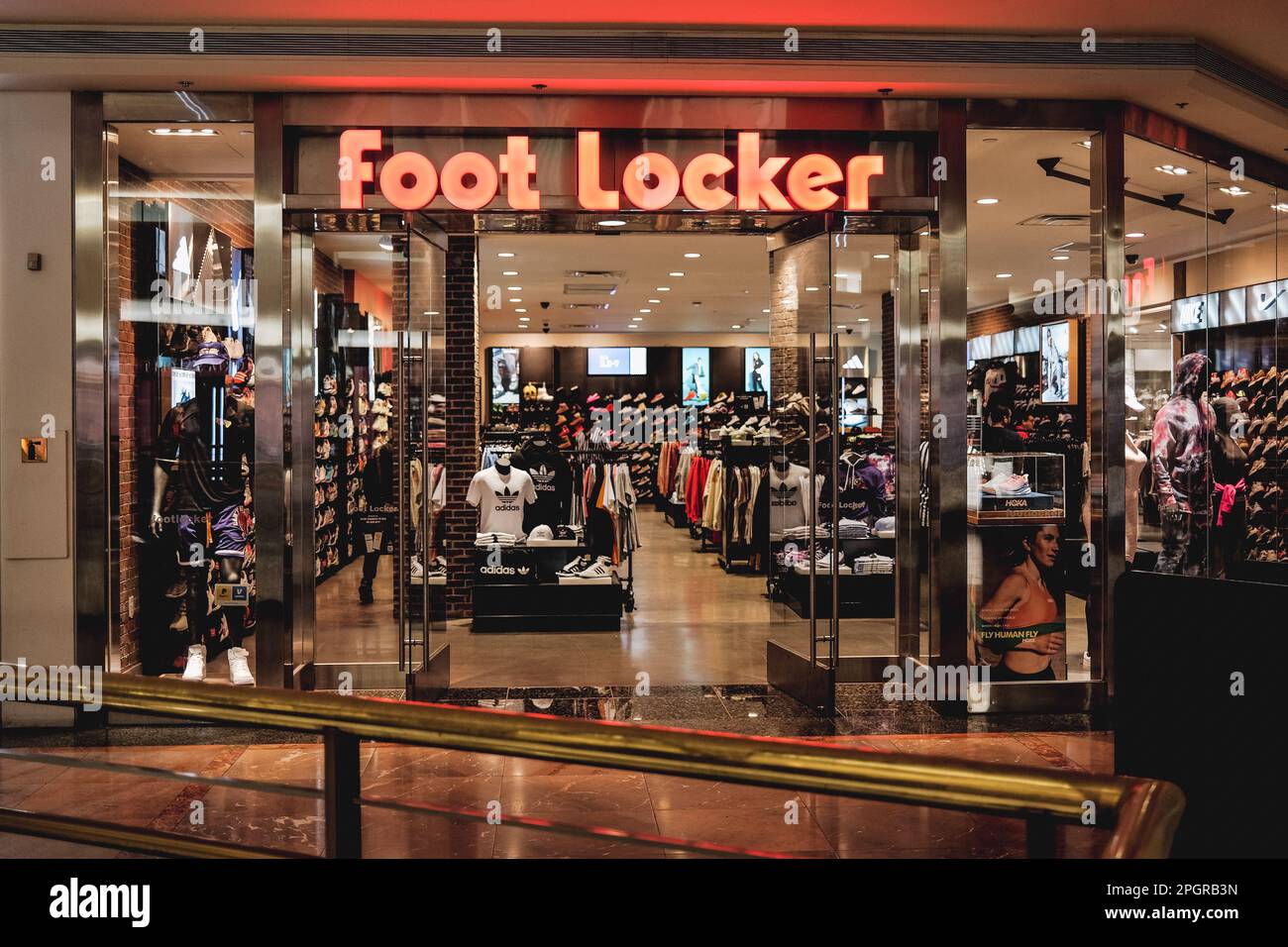 Ein Foto zeigt das Äußere eines Footlocker Stores, mit seinem berühmten schwarz-weißen Logo auf rotem Hintergrund über dem Eingang. Foot locker, der in den USA ansässige Schuhhändler, durchläuft derzeit in Asien einen Wandel, da es sein Geschäftsmodell vereinfachen und sich auf Kernregionen und Banner konzentrieren will. In diesem Rahmen wird Foot locker sowohl seine eCommerce- als auch seine Ladengeschäfte in Hongkong und Macau schließen und gleichzeitig alle seine derzeitigen eigenen und selbstbetriebenen Ladengeschäfte und eCommerce in Singapur und Malaysia auf ein Lizenzmodell umstellen. Foot locker's vierte Quartal 2022 Wiederaufnahme Stockfoto