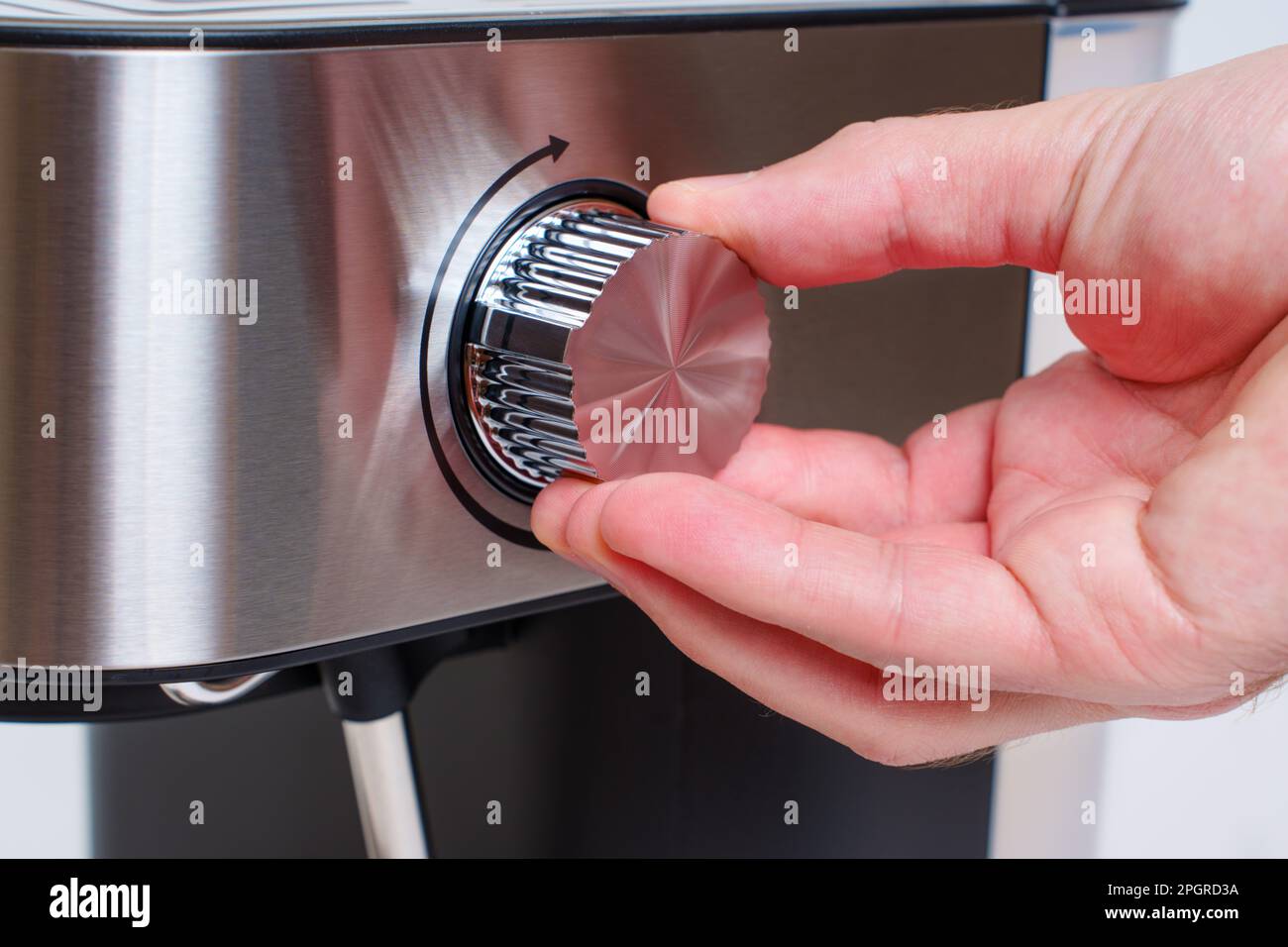 Nahaufnahme einer Hand, die den Dampfregler einer Espressomaschine für zu Hause greift. Stockfoto