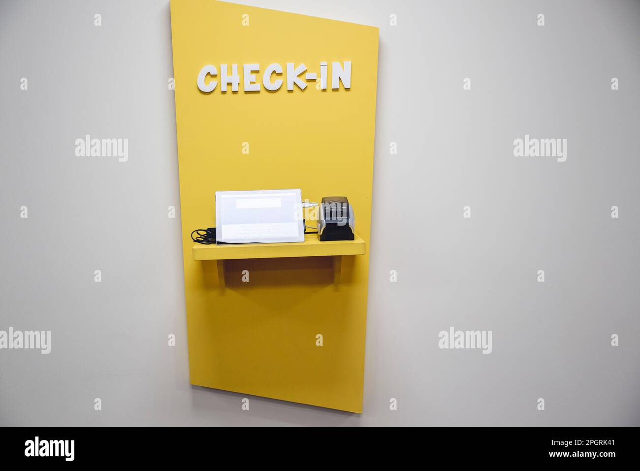 Ein gelber automatischer Check-in-Automat, der an der Wand montiert ist. Stockfoto