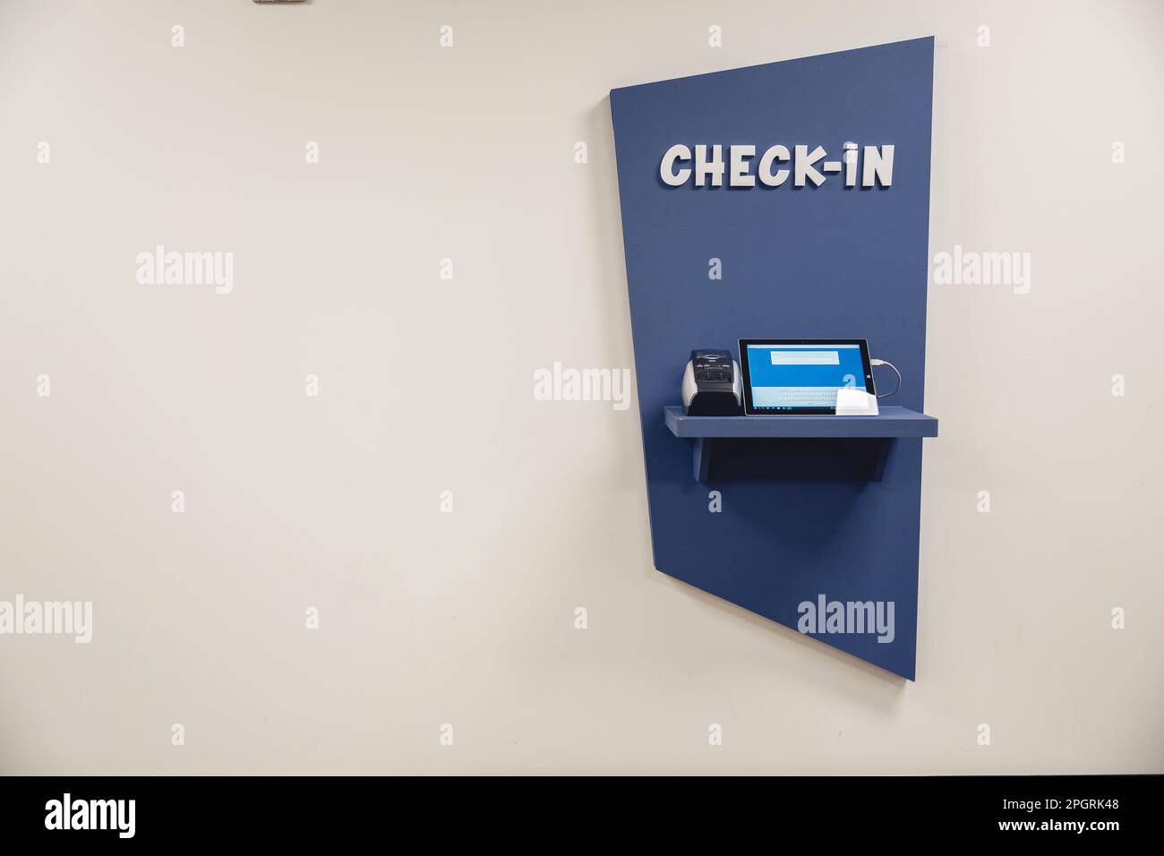 Ein blauer, automatischer Check-in-Automat, der an der Wand montiert ist. Stockfoto