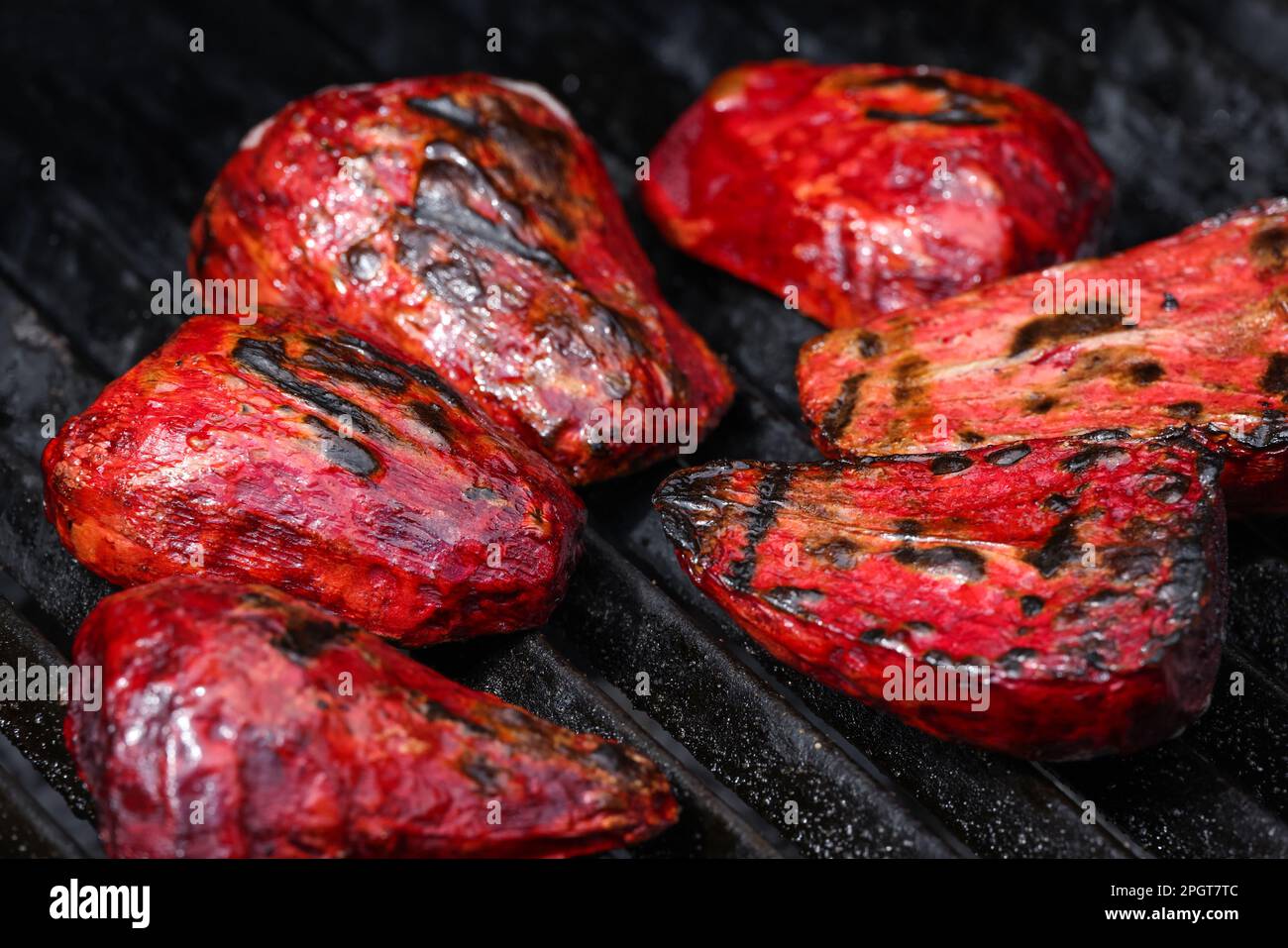 Nahaufnahme Kochen frische neue rote Rüben Wurzeln in Outdoor Holzkohlegrill mit Gusseisen Metallgitter, High-Angle-Ansicht Stockfoto
