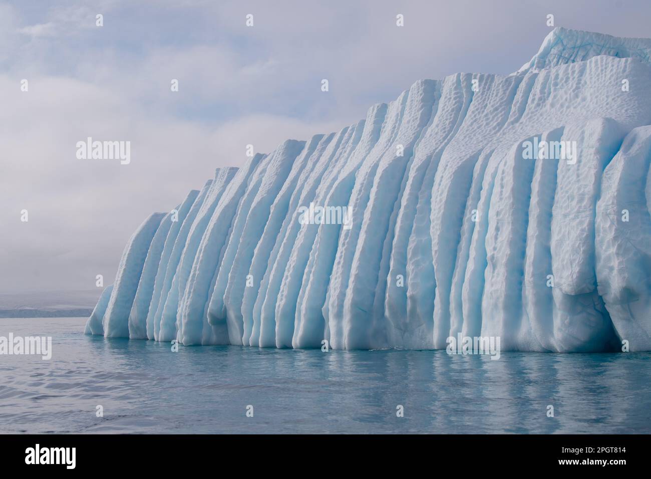 Riesiger Eisberg mit tief geschnitzten Seiten, die im stillen antarktischen Ozean schweben Stockfoto