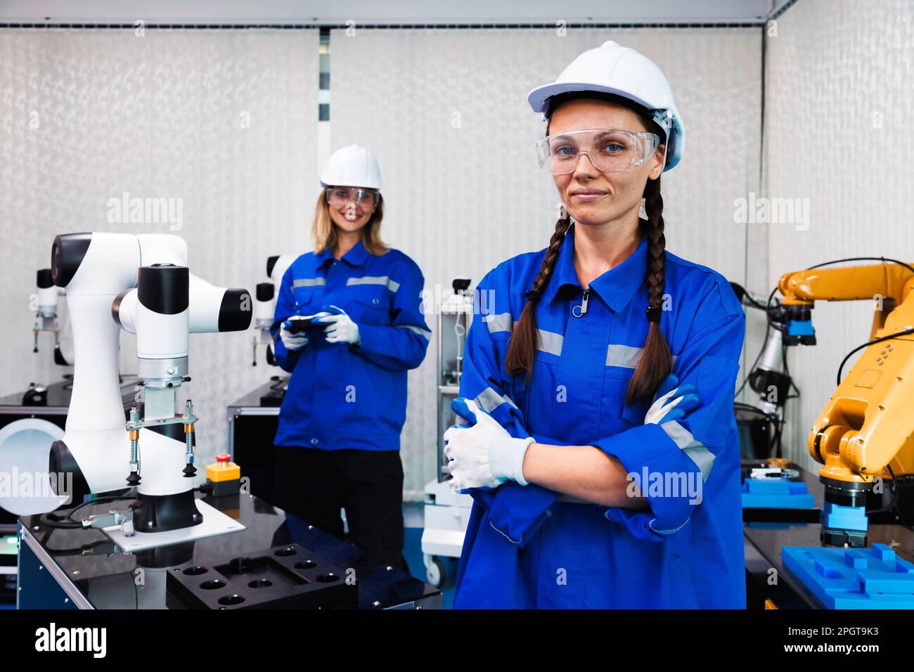 Studentinnen in der Automationstechnik studieren und kontrollieren Roboterarmmaschine in Universitäten oder Fabrikwerkstätten. ki-Robotertechnologie New i Stockfoto