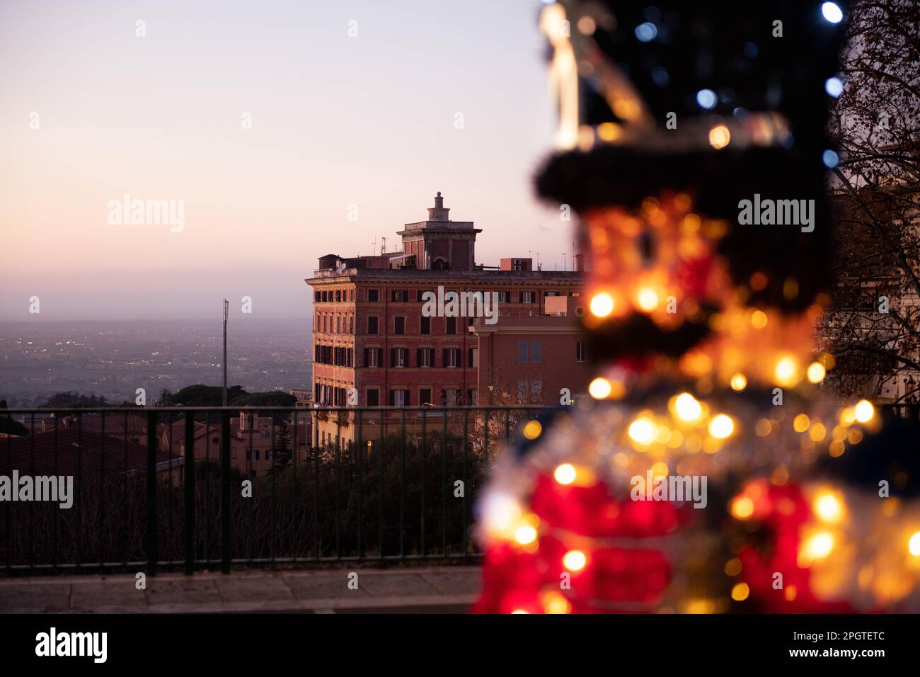 Die Weihnachtsdekoration glänzt vor dem alten römischen Haus und bietet einen weiten Blick auf Rom. Stockfoto