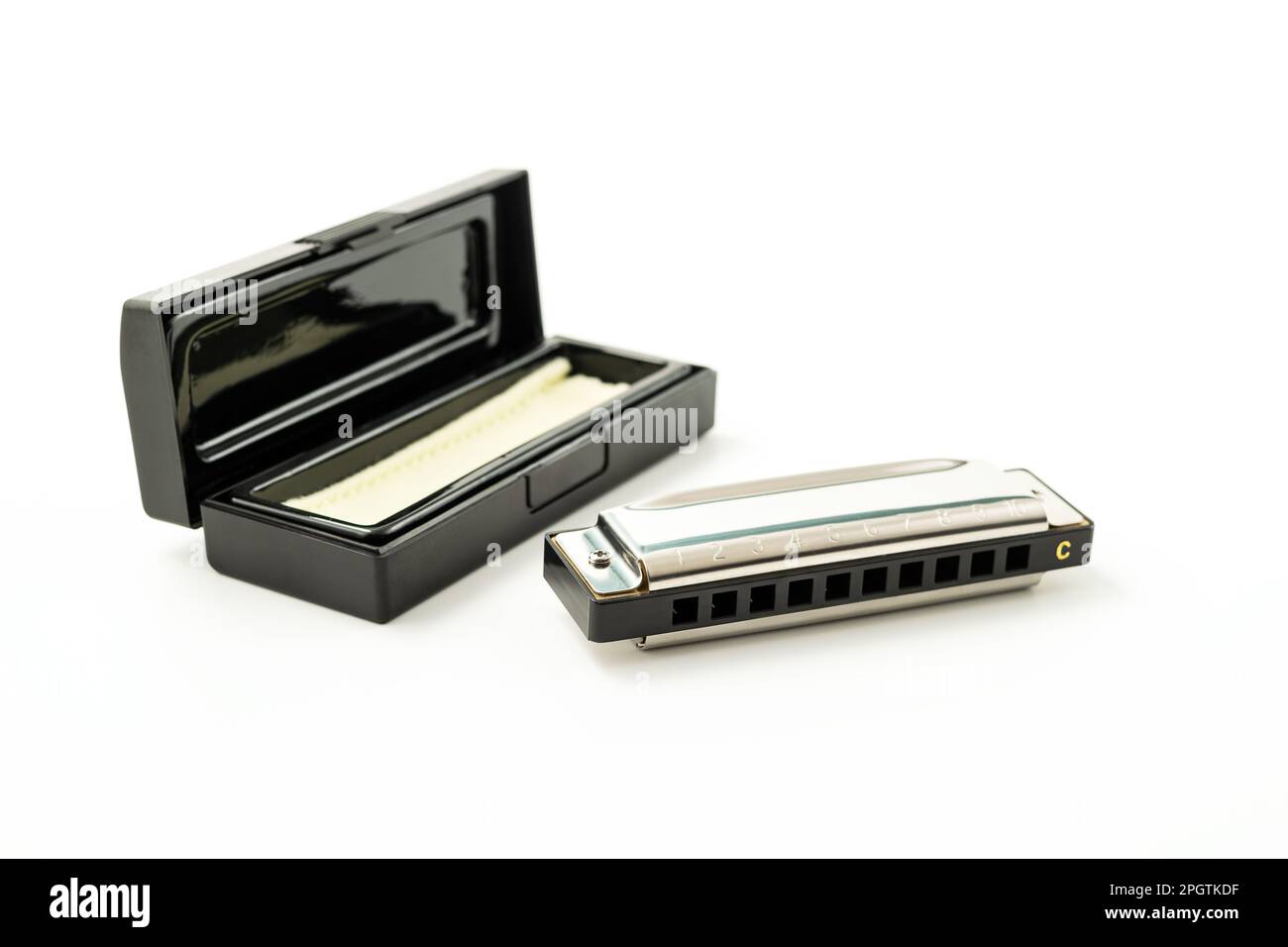 Harmonica, auch französische Harfe, Blauharfe, isoliert auf weißem Hintergrund mit ihrem Fall. FreiSchilf-Windinstrument, das weltweit in Blues, Folk, Jazz verwendet wird Stockfoto