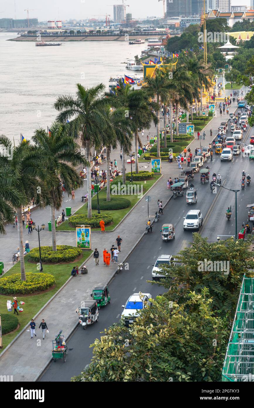 Viele kambodschanische Autos, Motorräder und Khmer Menschen bei Sonnenuntergang, geschäftigste Tageszeit. Sisowath Quay, eine beliebte Strip und Fußgängerzone, Leute und Familien CO Stockfoto