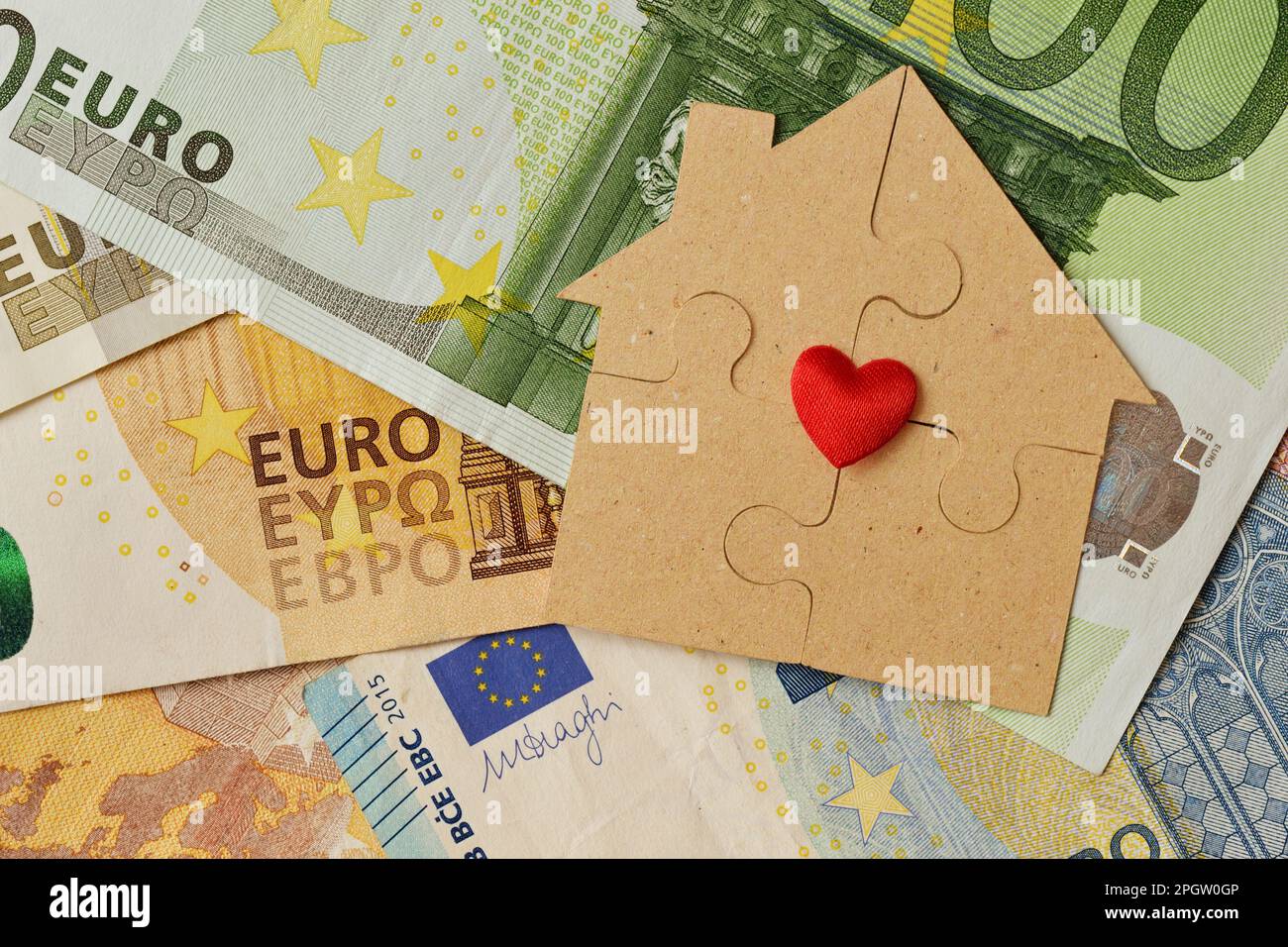 Puzzlehaus aus Recyclingpapier auf Euro-Banknoten - Hauskonzept, Baubonus und Ökologie Stockfoto