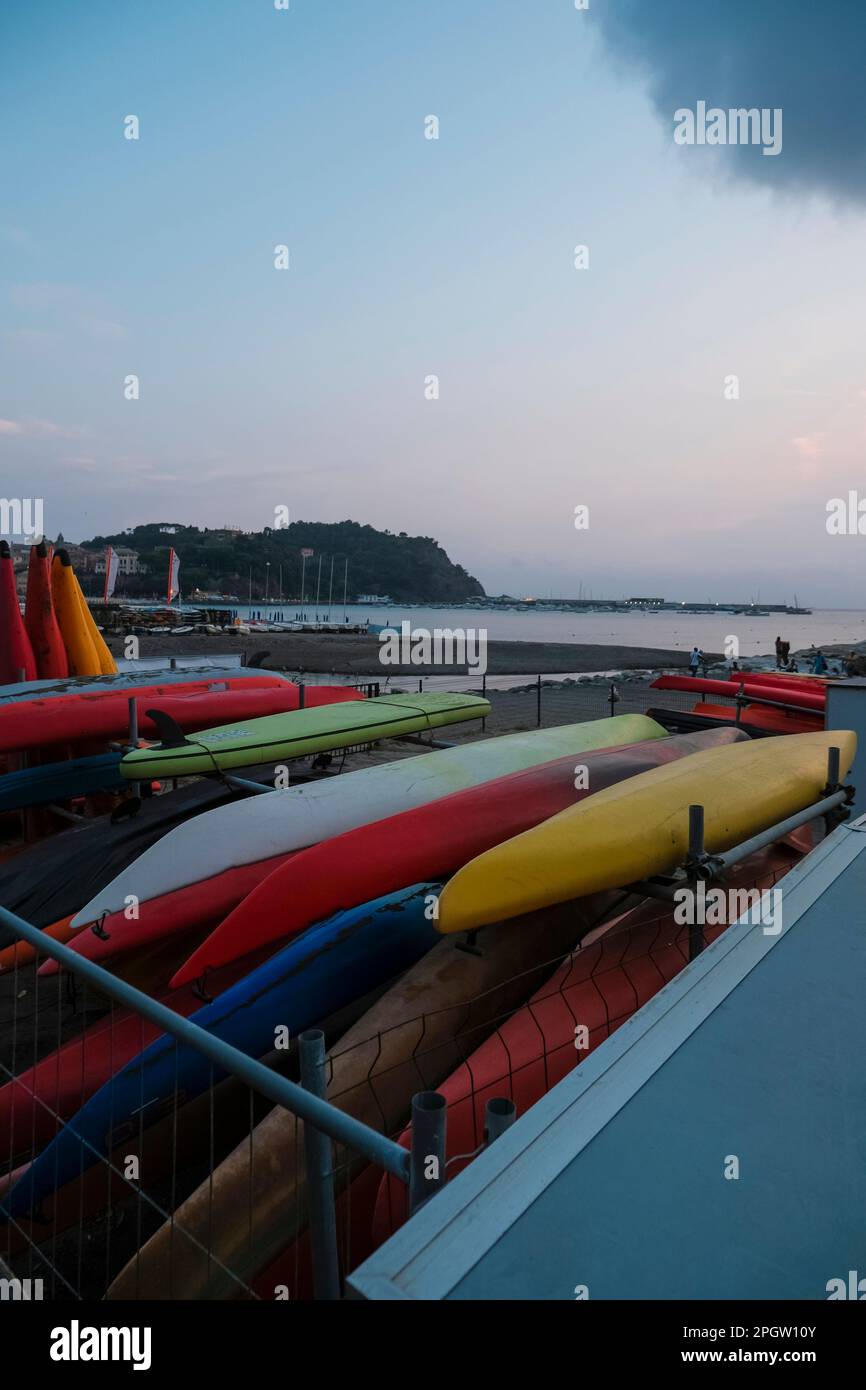 Farbenfrohe Kajaktour am Strand über die Küste und den Sonnenuntergang in Sestri Levante, Ligurien, Italien. Meeressport, aktiver Lifestyle Stockfoto