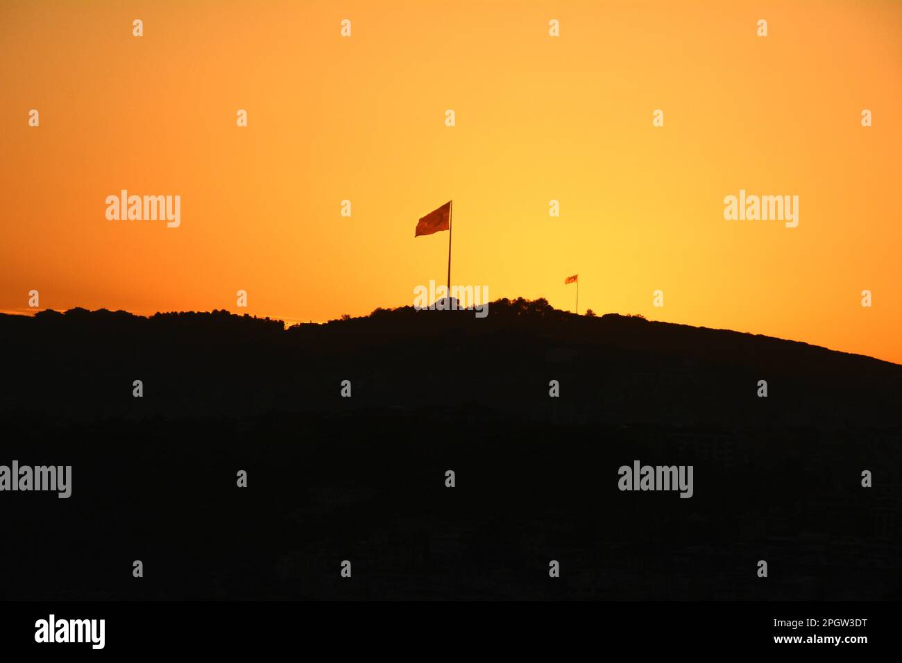 Ein Paar türkische Flaggen bei Sonnenaufgang am Camlica Hill in Silhouette, ein Park mit Blick auf den Bosporus auf der asiatischen Seite von Istanbul, Türkei/Turkiye. Stockfoto