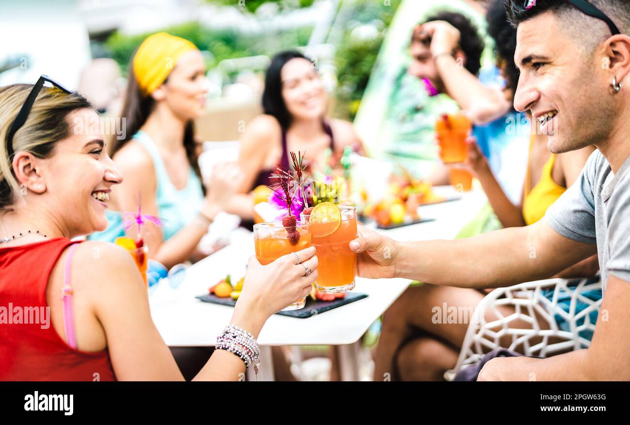 Fröhliche Leute, die Cocktails auf einer schicken Poolparty trinken - junge Freunde, die Spaß im Luxus-Resort-Restaurant haben - Ferienleben-Stil-Konzept mit Männern und Stockfoto