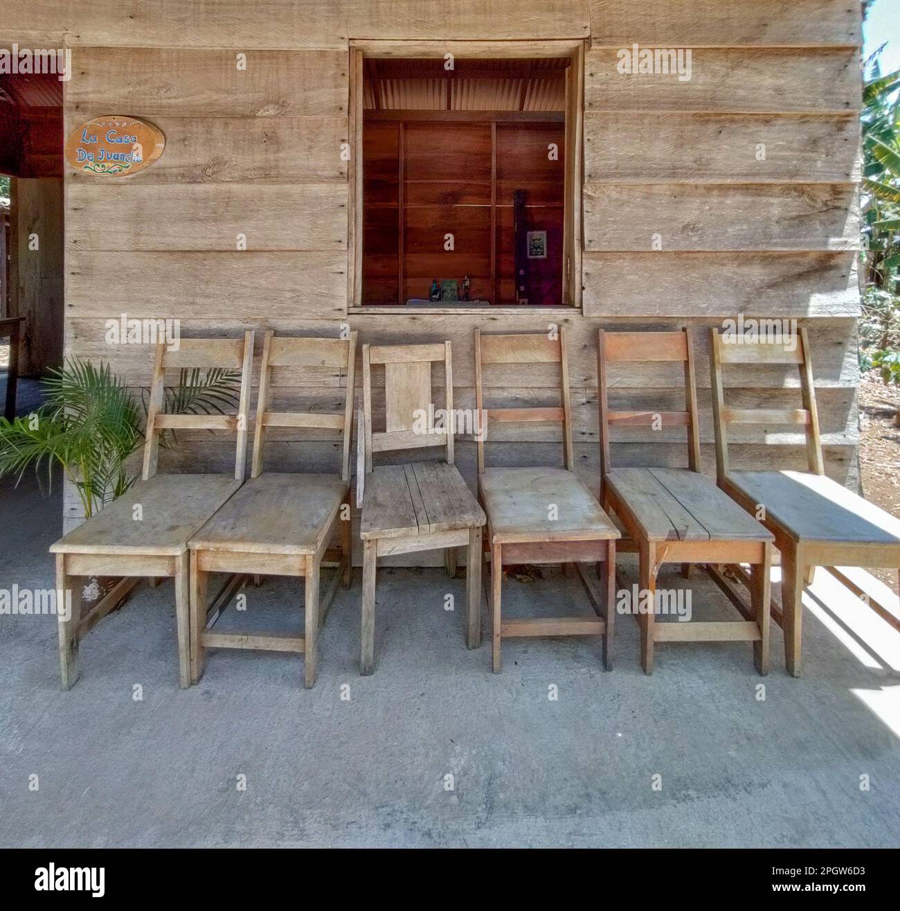 Naranjo, Costa Rica: Holzstühle vor einer traditionellen Costa-ricanischen Casita (Bauernhaus) in der Kaffeefarm Espiritu Santo und Verarbeitungsanlage. Stockfoto