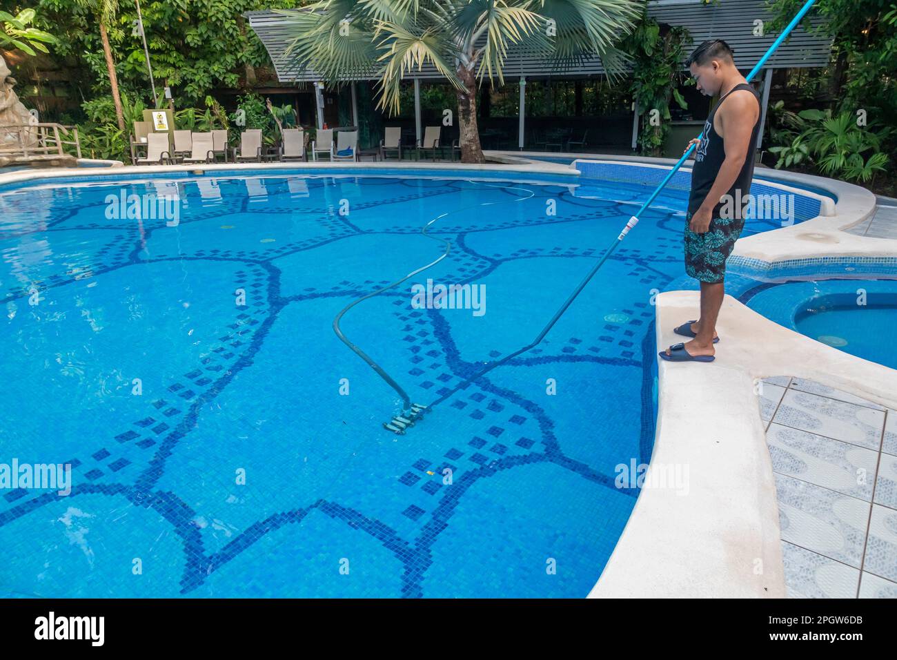 Tortuguero-Nationalpark, Costa Rica - Ein Mitarbeiter reinigt den Swimmingpool in der Evergreen Lodge, einem Hotel im Küstenregenwald. Stockfoto