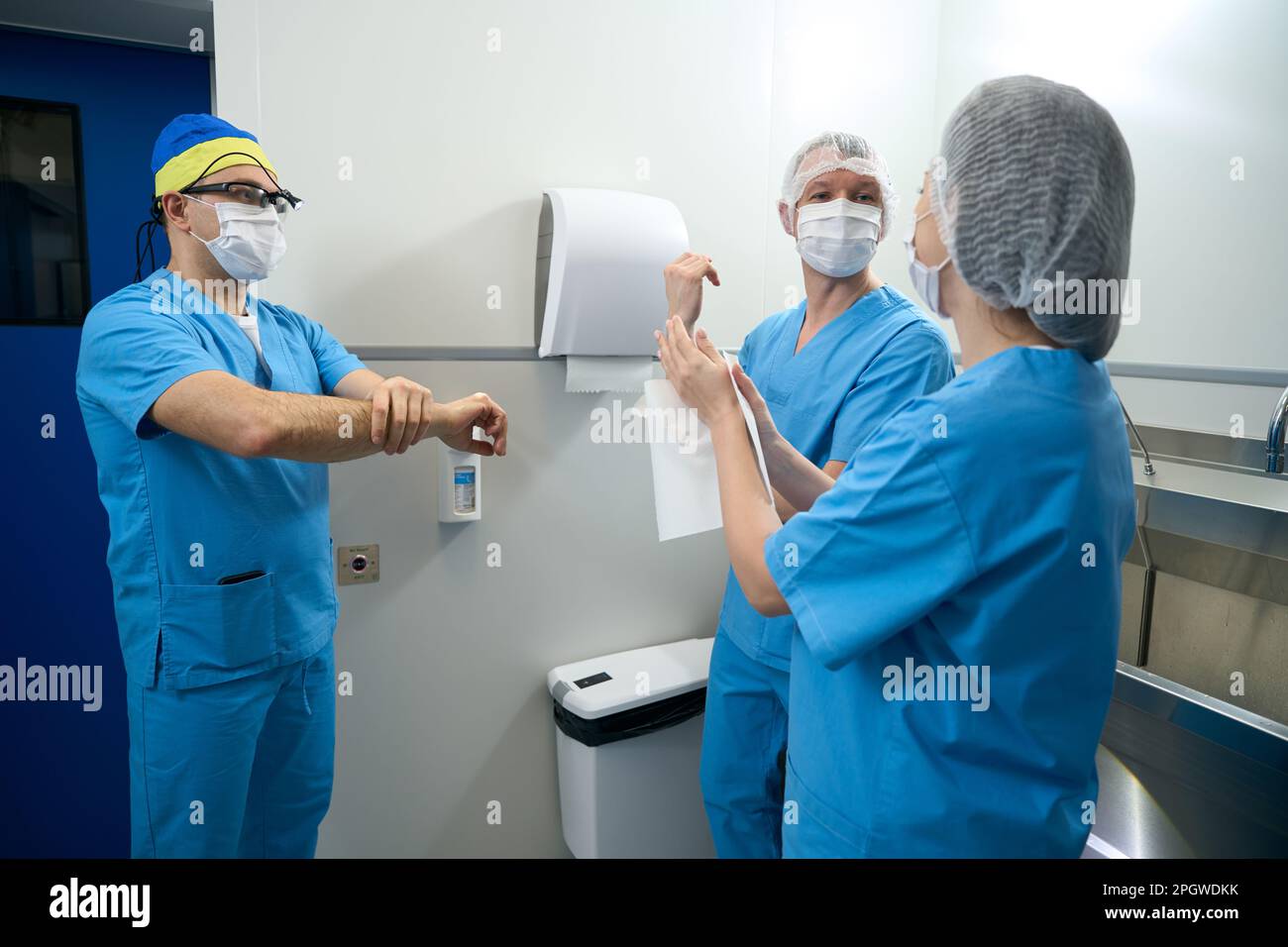 Medizinisches Personal behandelt Hände mit Desinfektionsmittel vor einer Operation Stockfoto