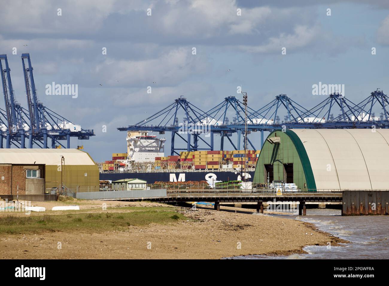 Blick über Harwich Navyard Wharf auf den Hafen von Felixstowe, wo das Containerschiff MSC Narissa im Hintergrund liegt. Stockfoto