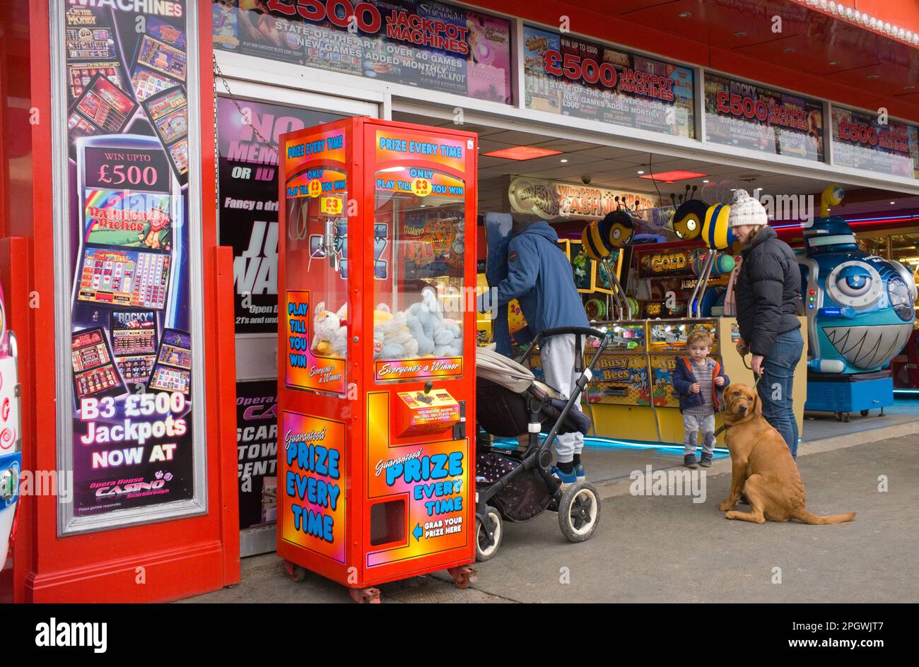 Familie mit einem kleinen Kind und einem Hund in einer Spielhalle in Scarborough Stockfoto