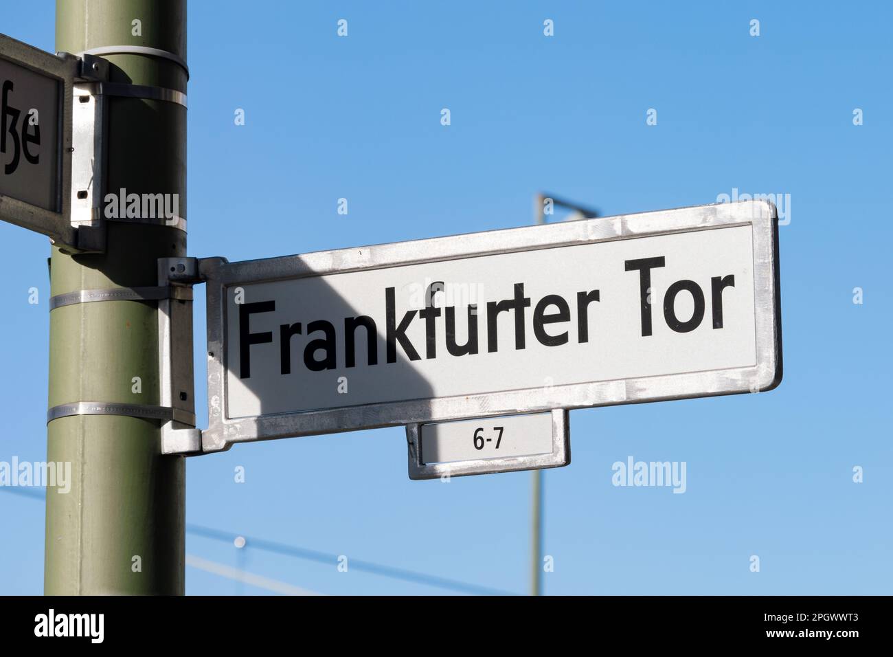 Frankfurter Tor Straßenschild in Berlin Friedrichshain. Metallrahmen mit einer weißen Platte innen. Die Buchstaben sind auf dem Schild schwarz gedruckt. Stockfoto