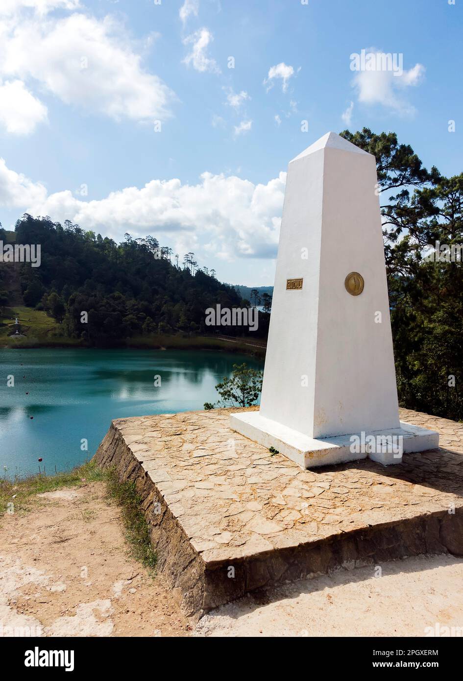 Steinobelisk an Land und booyerte Linie über einen See markiert die Grenze zwischen Guatamala und Mexiko Stockfoto