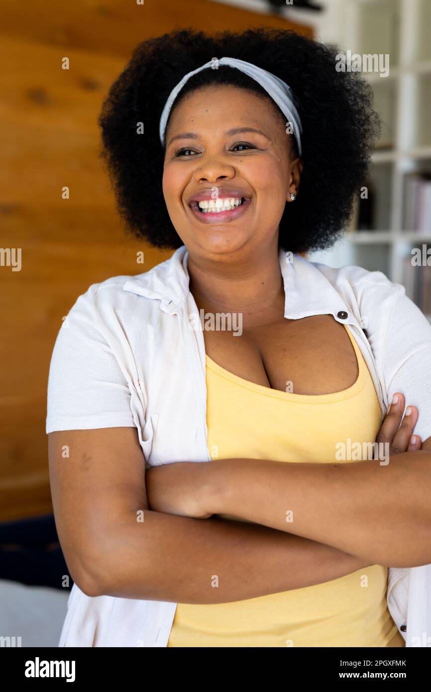 Eine glückliche afroamerikanerin in Übergröße, die wegsieht und lächelt Stockfoto