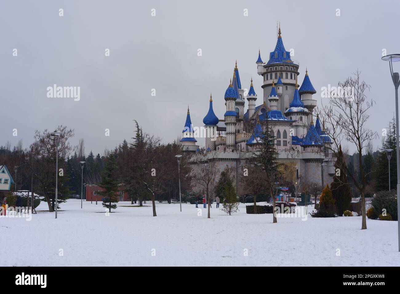 Nostalgische alte Burg im Sazova Park Eskisehir mit blauen Türmen. Unter Schnee an einem kalten Wintertag mit Bäumen und Büschen unter Schnee. Stockfoto