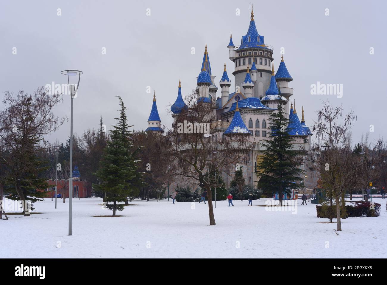 Nostalgische alte Burg im Sazova Park Eskisehir mit blauen Türmen. Unter Schnee an einem kalten Wintertag mit Bäumen und Büschen unter Schnee. Stockfoto