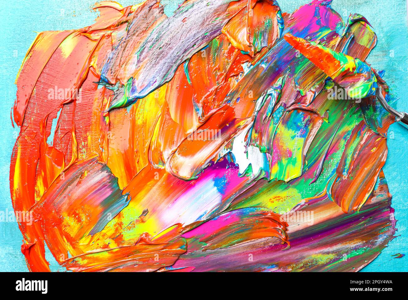 Bunte Acrylfarben und Malmesser auf Leinwand, Draufsicht Stockfoto