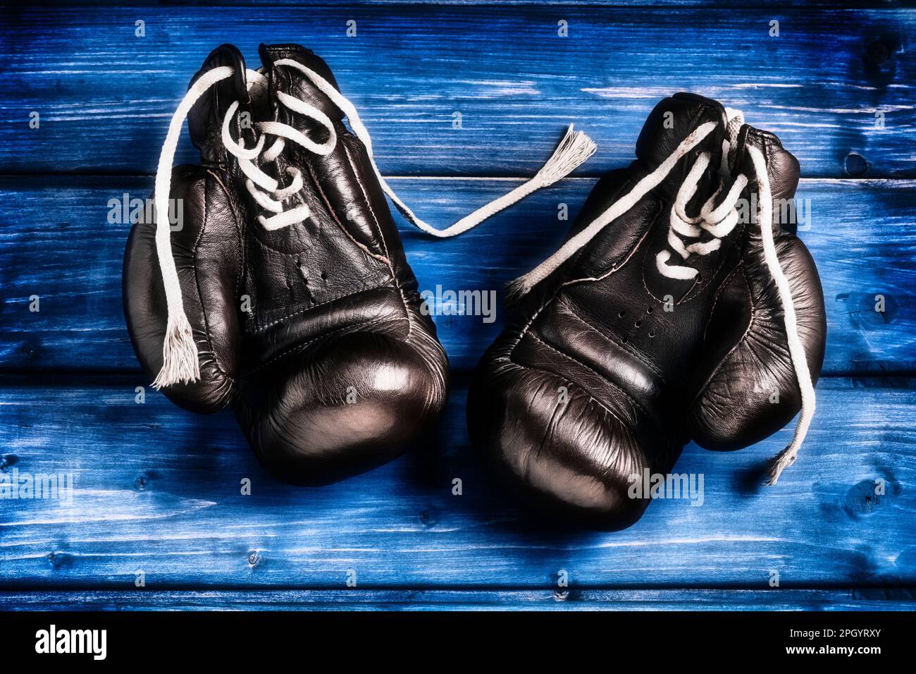 Boxhandschuhe auf blauem Holzhintergrund Stockfoto