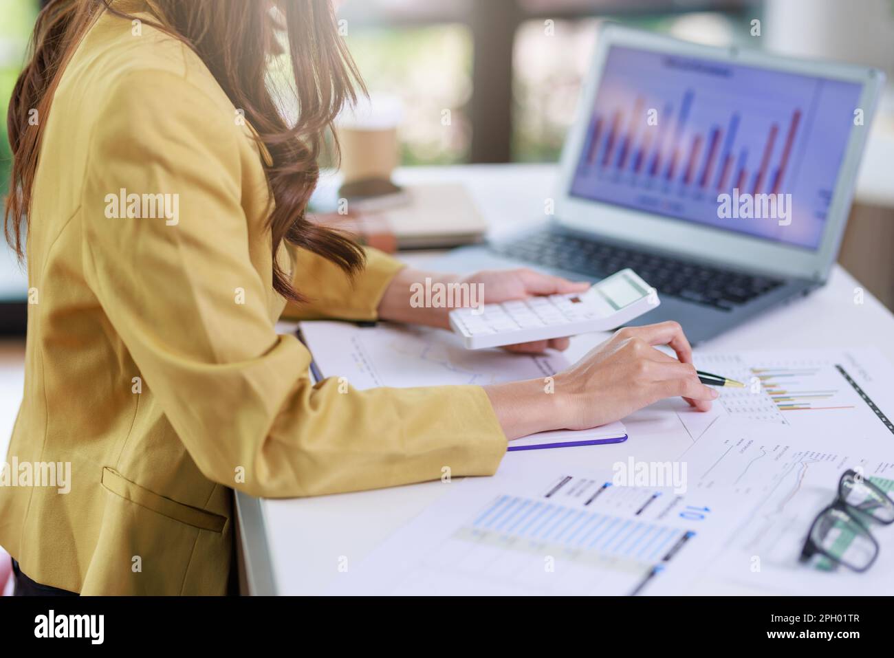 Konzept der arbeitenden Frau im Geschäftsbüro, Geschäftsfrau im Nahbereich, die ihren Investitionsplan überprüft, indem sie Dokumente und Diagrammdaten zu den Unternehmensinvestitionen analysiert Stockfoto