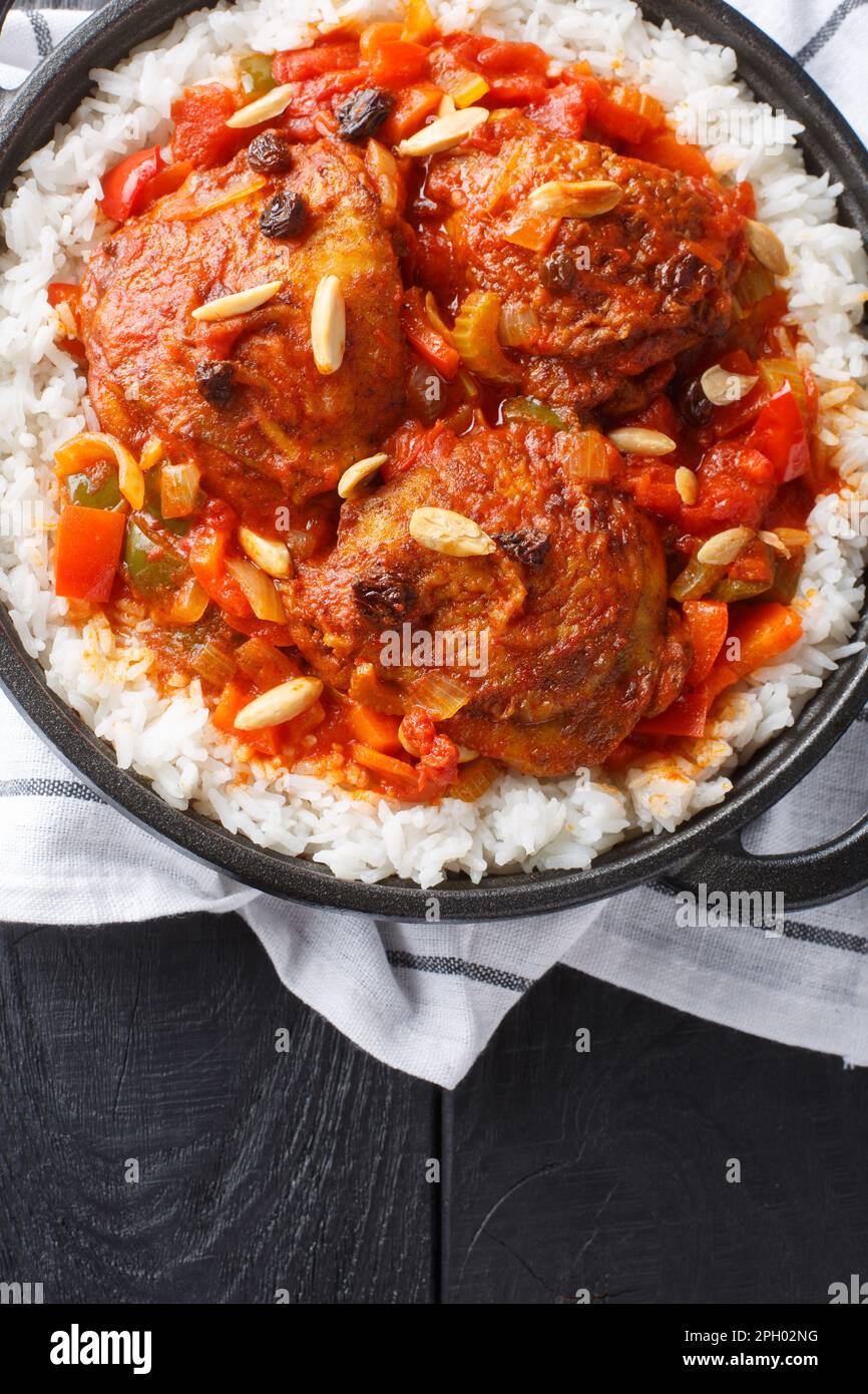 Hausgemachtes amerikanisches indianisches Käpt'n-Curry mit Hühnchen, serviert mit Reis in einer Pfanne auf dem Tisch. Vertikale Draufsicht von oben Stockfoto