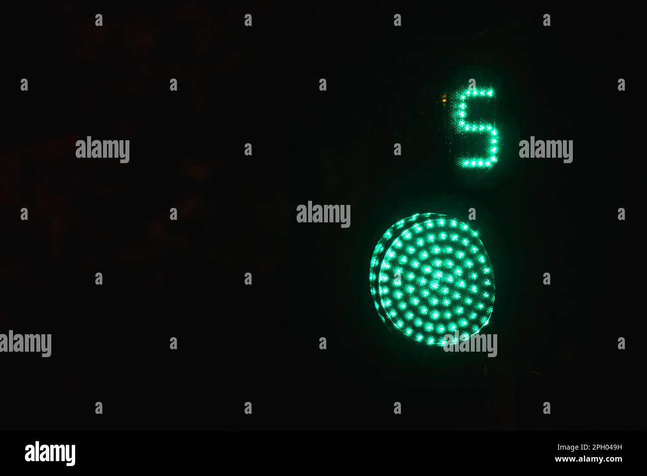Fußgänger-Ampel mit Sekunden-Timer zeigt grün an Signal kann über schwarzen Nachthintergrund gehen Stockfoto