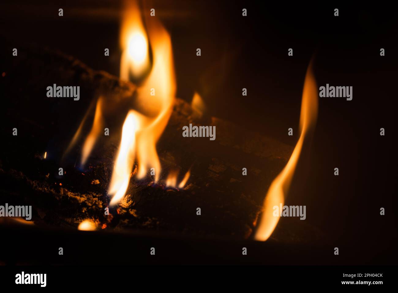 Langsam brennendes Feuer in einem Kamin in der Nacht, natürliche Nahaufnahmen mit selektivem Weichzeichner Stockfoto Langsam brennendes Feuer in einem Kamin in der Nacht, natürliche Nahaufnahmen mit selektivem Weichzeichner Stockfoto