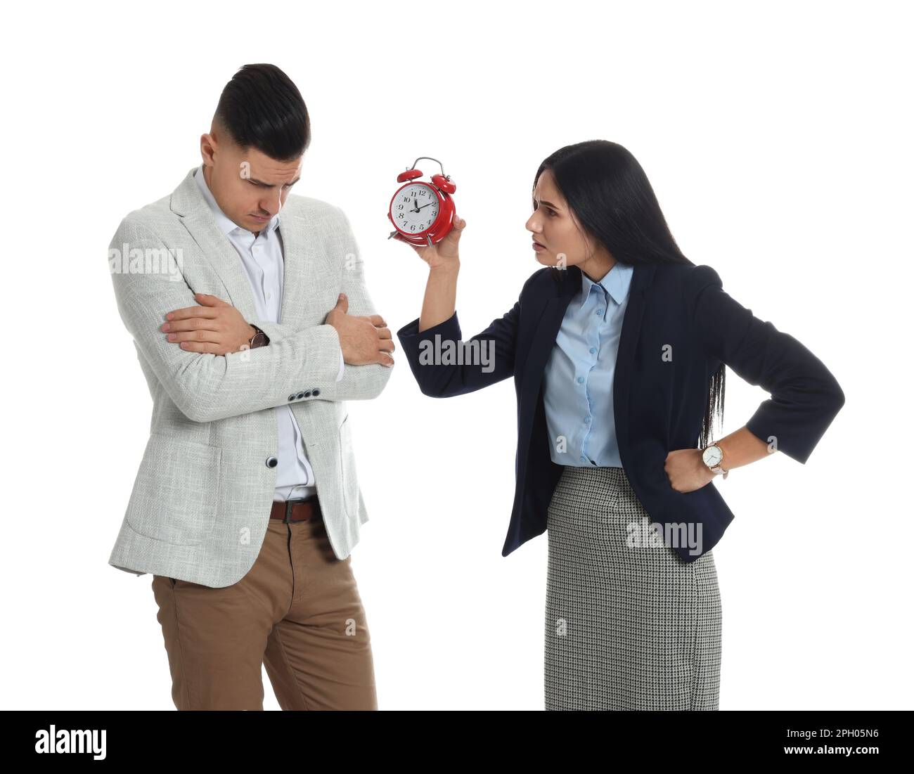 Geschäftsfrau mit Wecker, die Angestellte schimpft, weil sie zu spät auf weißem Hintergrund ist Stockfoto
