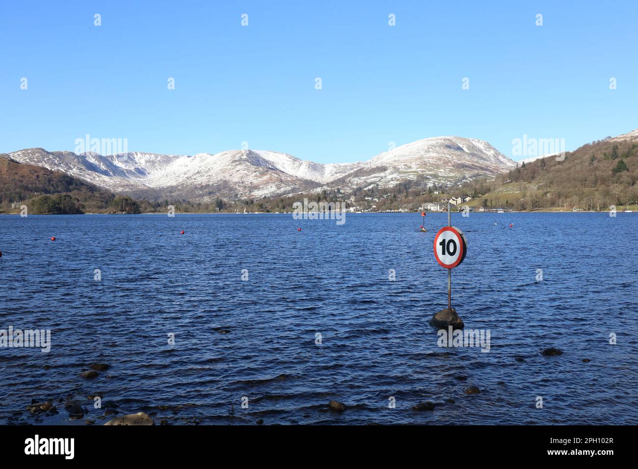 Geschwindigkeitsbegrenzung! Winter im englischen Lake District National Park und Schnee in den Cumbrian Mountains. Ein Schild, auf dem das Tempolimit auf Windermere steht. Stockfoto