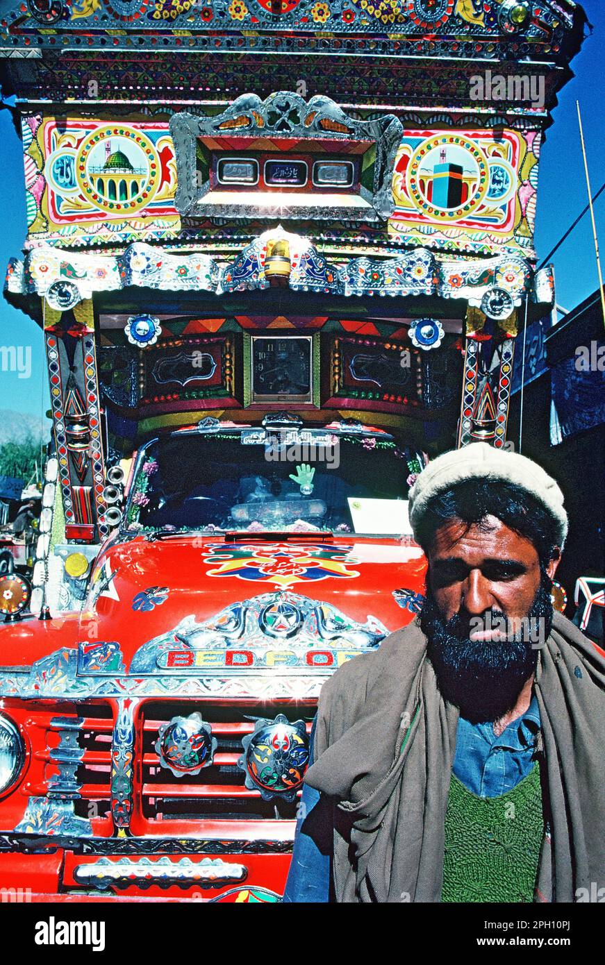 Pakistan. Gilgit. Karakoram-Gebirge. Ein einheimischer Mann mit dekoriertem Truck. Stockfoto