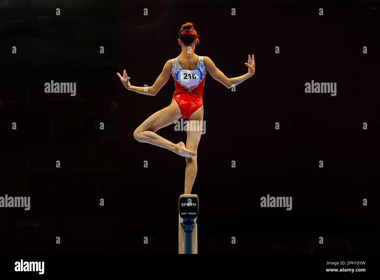 Eine Turnerin, die auf schwarzem Hintergrund Sport macht, das Modell Spieth Balance Beam Soft Touch, Sommersportspiele Stockfoto