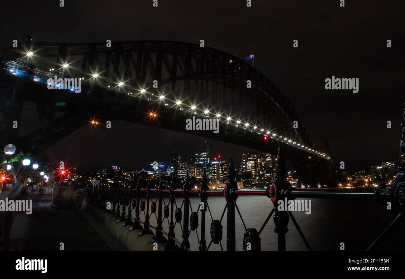 Sydney, Australien. 25. März 2023. Die Sydney Harbor Bridge wird während der Earth Hour in Sydney, Australien, am 25. März 2023 dunkel. Australiens Wahrzeichen, darunter das Opernhaus von Sydney und die Hafenbrücke von Sydney, wurden am Samstagabend für eine Stunde dunkel als Teil einer globalen Bewegung, um das Bewusstsein für Klimawandel und Naturverlust zu schärfen. Earth Hour 2023 soll das Bewusstsein für die Bedeutung von Bäumen und Natur für die Tierwelt, Gemeinden und das geistige und körperliche Wohlbefinden der Menschen schärfen. Kredit: Hu Jingchen/Xinhua/Alamy Live News Stockfoto