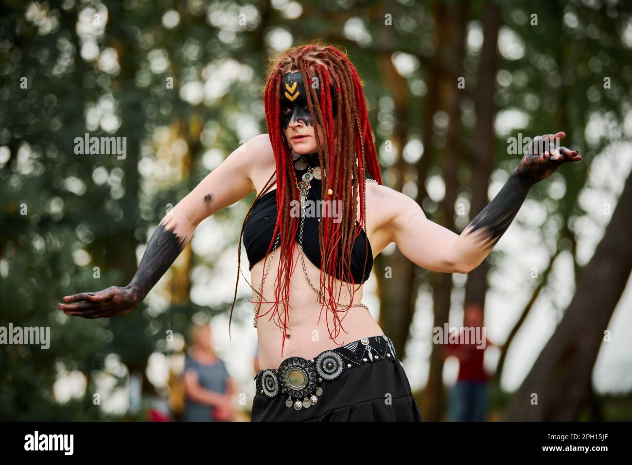 Mythologisches Tanzmädchen Faun auf grünem Rasen im öffentlichen Park Kunstveranstaltung im Freien mit mythologischer Atmosphäre. Ein Mädchen im Bild einer mythischen Kreatur Stockfoto