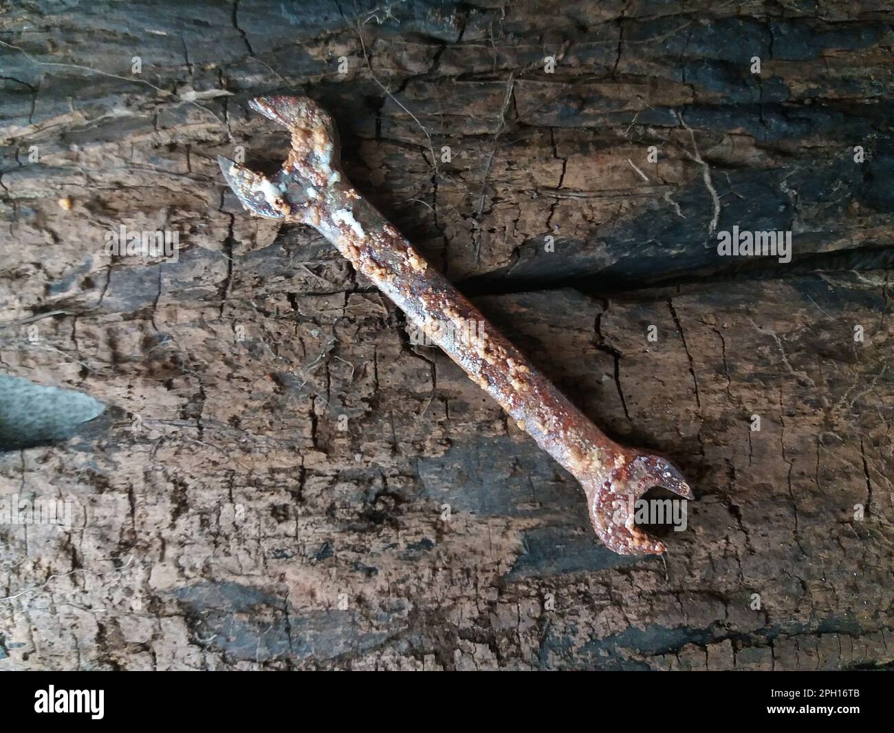 Maulschlüssel zerstört durch Rost, fotografiert auf einem alten Holz. Stockfoto