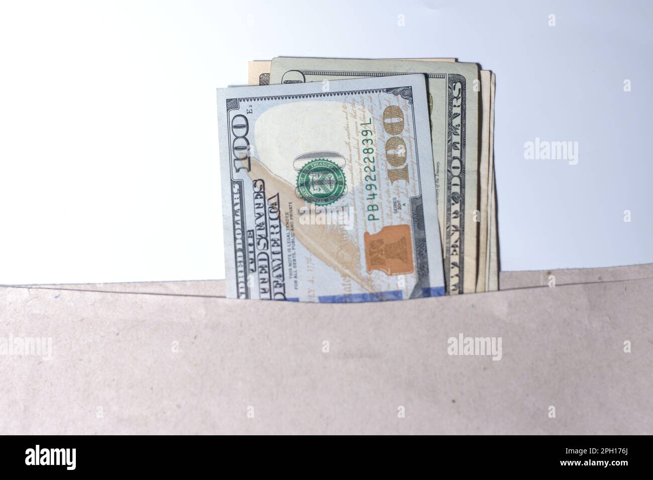 Hundert Dollar in einem Umschlag auf weißem Hintergrund Stockfoto