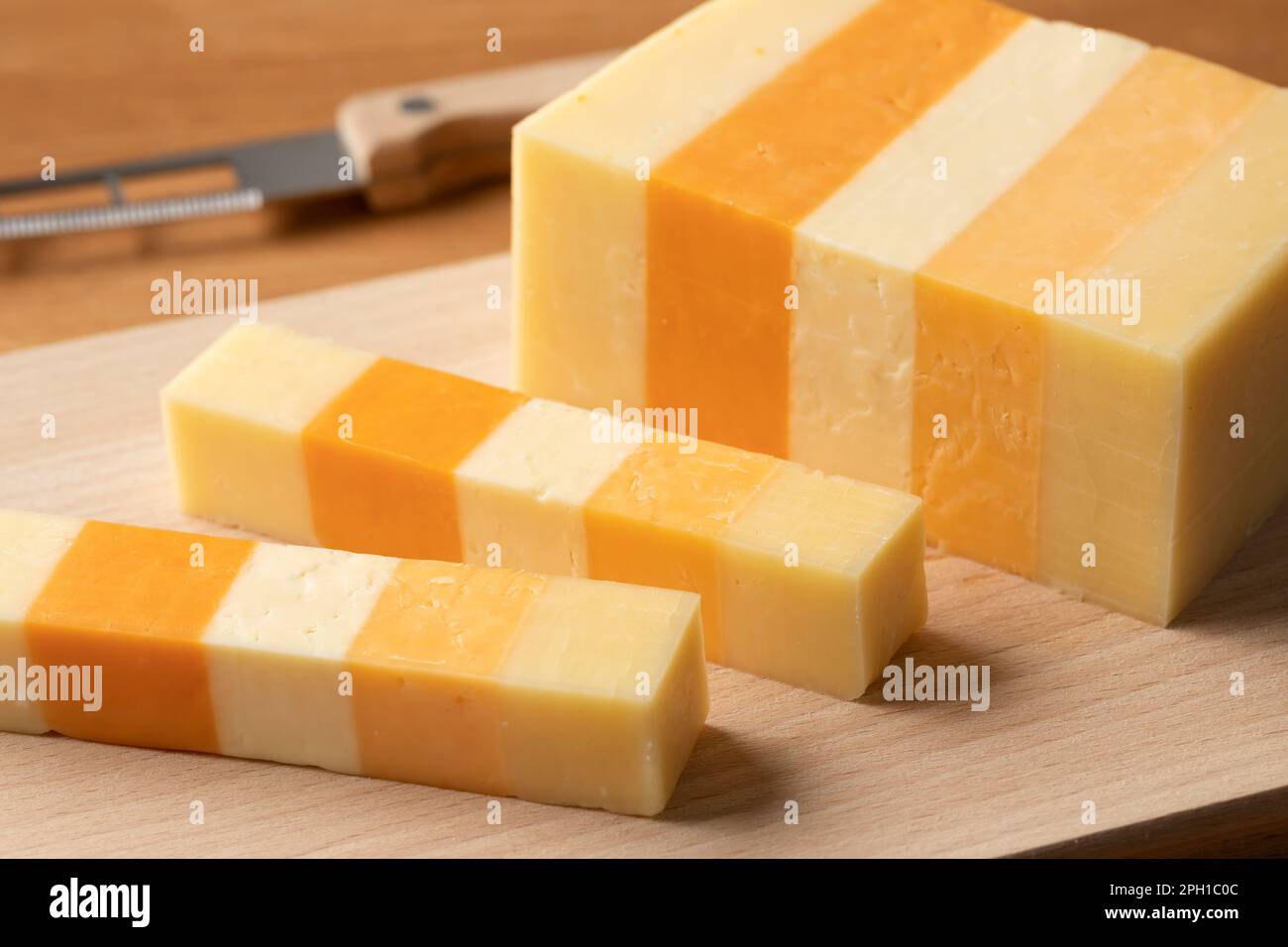 Ein Stück English Classic Five, eine Variante Cheddar Käse, auf einem Schneidebrett für einen Snack aus nächster Nähe Stockfoto