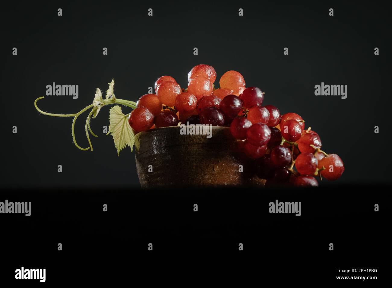 Eine Schüssel roter Trauben auf einem schwarzen Hintergrund Stockfoto