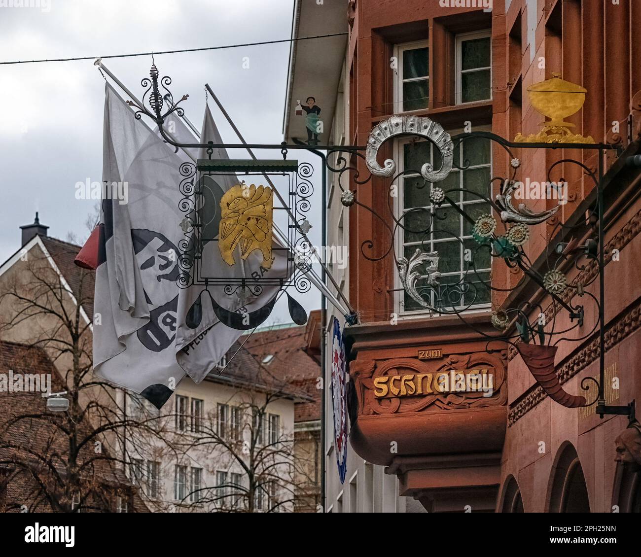 BASEL, SCHWEIZ - 27. FEBRUAR 2023: Kunstvolle Schilder und Flaggen in der Altstadt Stockfoto